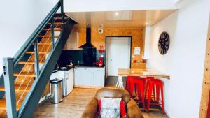 a kitchen with a staircase and a kitchen with red stools at Duplex industriel - Centre ville Parking privé WIFI in Angers