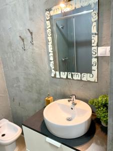 een badkamer met een witte wastafel en een spiegel bij Rincón Feliz in Corralejo