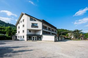 a large white building with a parking lot at Apartmány EMA a PETER in Terchová