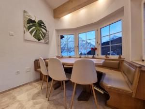 a dining room with a table and chairs and windows at Zum Lerch Penthouse in Saas-Fee