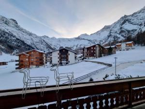 a view of a resort with snow covered mountains at Zum Lerch Penthouse in Saas-Fee