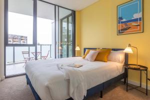 um quarto com uma cama grande e janelas grandes em KULA Parramatta em Sydney