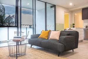 シドニーにあるKULA Apartments Parramattaのソファとテーブルのあるリビングルーム