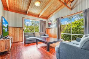 Una sala de estar con sofás, un televisor y una mesa. en Echuca 265 - Echuca Holiday Homes, en Echuca