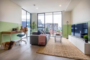 uma sala de estar com um sofá e uma secretária em KULA Parramatta em Sydney