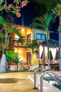 a house with palm trees in front of it at Ville Sweet Home in Canoa Quebrada