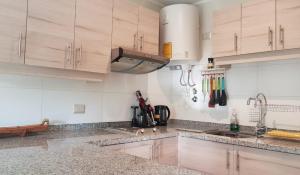 a kitchen with marble counter tops and wooden cabinets at Departamento en la naturaleza de Pucón in Pucón