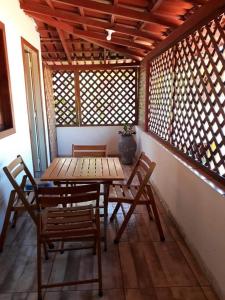 un tavolo in legno con sedie in una stanza con finestre di Pousada Maresias Guriri a Guriri