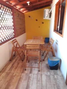 Pousada Maresias Guriri في غوريري: طاولة وكراسي خشبية في غرفة مع فناء