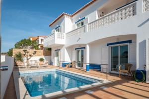 een villa met een zwembad en een huis bij Casa da costa in Carrapateira