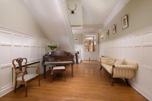 a living room with a piano and a couch at Lys-Na-Greyne in Aboyne