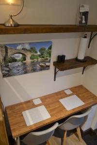 una mesa de madera con 2 sillas y una foto en la pared en Dalecote Barn Bed and Breakfast (Bunkroom) en Ingleton 
