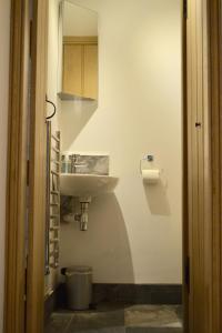 Baño blanco con lavabo y espejo en Dalecote Barn Bed and Breakfast (Bunkroom) en Ingleton 