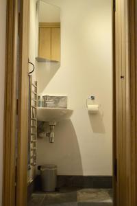 un bagno bianco con lavandino e specchio di Dalecote Barn Bed and Breakfast (Bunkroom) a Ingleton Altre 12 foto