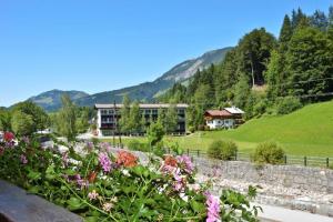 a garden with flowers in front of a building at Pension Maislinger in Fieberbrunn