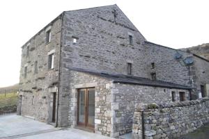 an old stone building with a stone wall at Dalecote Barn Bed and Breakfast (Bunkroom) in Ingleton +12 photos