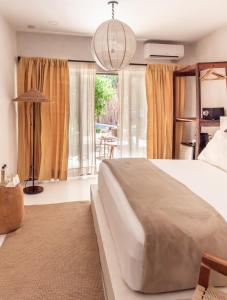 a bedroom with a large bed and a large window at Dune Boutique Hotel located at the party zone in Tulum