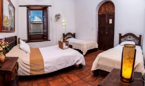a room with three beds and a table with flowers at La Serrana Hostal Spa in Socorro