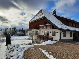 ein Haus mit einem schneebedeckten Dach auf einer Backsteinstraße in der Unterkunft Hubertus Lodge in Ibach