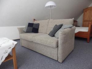 sala de estar con sofá y almohadas en Apartment Hillmer, en Niederhaverbeck