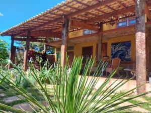 une maison avec une pergola en bois sur une terrasse dans l'établissement Casas e apartamentos da Praia, Lapinha na beira do lago, à Santana do Riacho