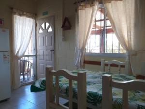 1 dormitorio con 2 camas y 2 ventanas en Cabanas Valle Azul en Villa Rumipal