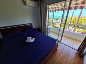 una camera con un letto blu e un asciugamano sopra di Le Lis Vacances et Affaire Cosy vue Mer a Le Lamentin