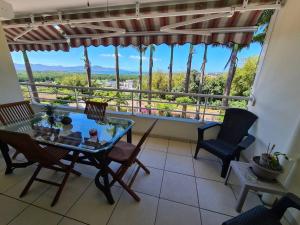 una sala da pranzo con tavolo e sedie e un balcone di Le Lis Vacances et Affaire Cosy vue Mer a Le Lamentin