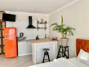 uma cozinha com um frigorífico laranja e um balcão em Апартаменти з неймовірною ванною em Kiev
