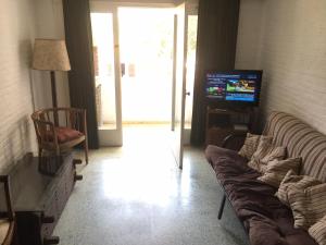 sala de estar con sofá y TV en Apto San Rafael Viña del Mar, en Punta del Este