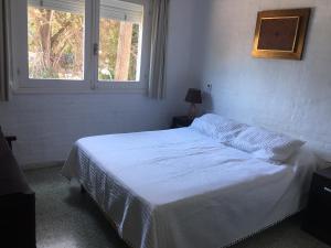 1 dormitorio con 1 cama con sábanas blancas y ventana en Apto San Rafael Viña del Mar, en Punta del Este