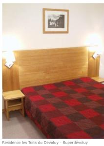 - une chambre dotée d'un lit avec une couverture rouge et noire dans l'établissement " B17 " T2-4p de standing au pied des pistes de Superdévoluy - "résidence Les Toits du Dévoluy" - Vue Magnifique -, à Saint-Étienne-en-Dévoluy