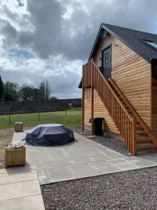 a wooden building with a ramp and a stair case at Cosy Country Modern Studio with Patio Space. in Crieff