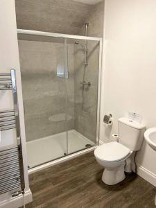 a bathroom with a toilet and a glass shower at Cosy Country Modern Studio with Patio Space. in Crieff