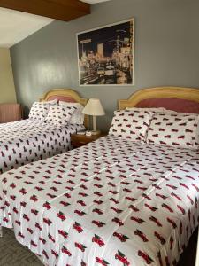 1 dormitorio con 2 camas y edredón rojo y blanco en HOMETOWN INN, en Charles City