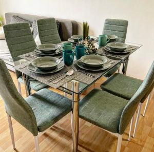 a dining room table with chairs and plates on it at Apartman De Luxe in Donovaly
