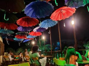 a group of people sitting at tables under umbrellas at Hotel Pousada Villas do Atlantico in Lauro de Freitas