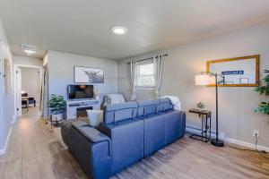 a living room with a blue couch and a tv at The Pathside Cottage in Montrose