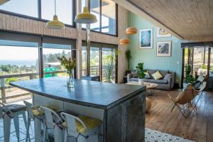 una cocina con una isla grande en una habitación con ventanas en Casa Alma - Punta de Lobos, en Pichilemu