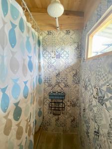 y baño con ducha y azulejos azules y blancos. en Serás Libre Refugio, en Zipaquirá