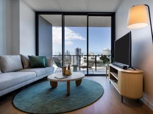 a living room with a couch and a tv at The Star Residences - Gold Coast in Gold Coast