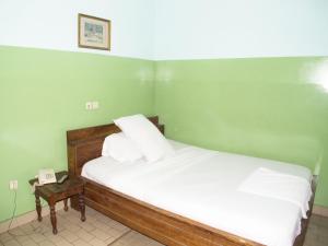 a bedroom with a bed and a nightstand with a phone at Royal hotel in Lomé