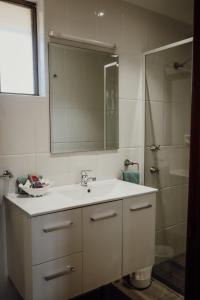 a white bathroom with a sink and a shower at Denman Motor Inn in Denman