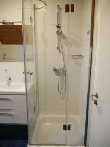 a shower with a glass door next to a sink at Fewo 2748 in Tossens in Tossenserdeich