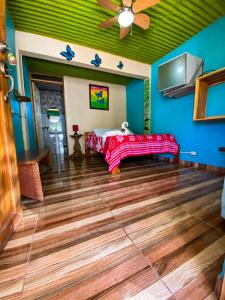 a room with a bed and a ceiling fan at Cabinas Cascada Rio Celeste in Bijagua