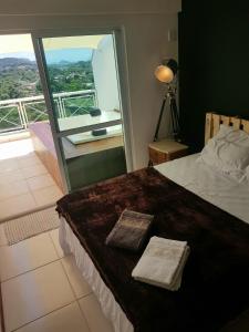 um quarto com uma cama e uma grande janela em Cobertura Loft-Jacuzzi-Piscina-Praias-Super Vista em Niterói