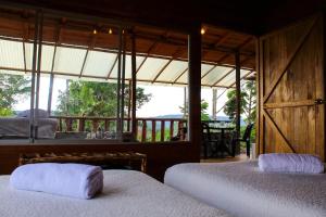 two beds in a room with a view of the ocean at Cacao Glamping Lodge & Experience in Cotundo