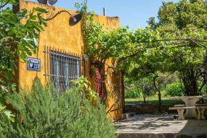 a yellow building with a gate and a sign on it at Chacra La Mondiola del Este in Ciudad de la Costa