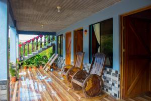 a group of chairs sitting on the porch of a house at Cabinas Cascada Rio Celeste in Bijagua