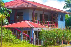 a house with a red roof at Cabinas Cascada Rio Celeste in Bijagua